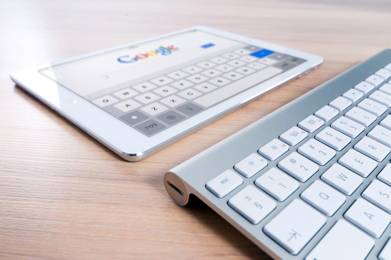 A keyboard and a tablet with the screen showing the Google homepage